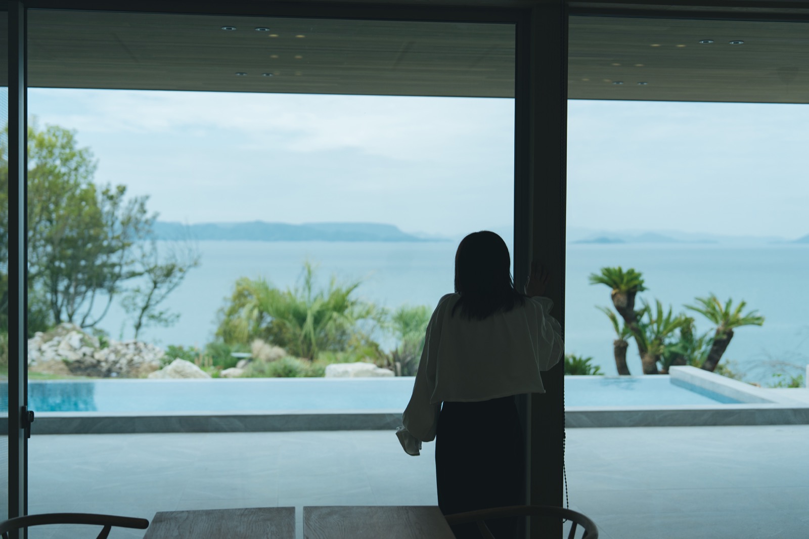 窓越しに海とプールを眺める朝